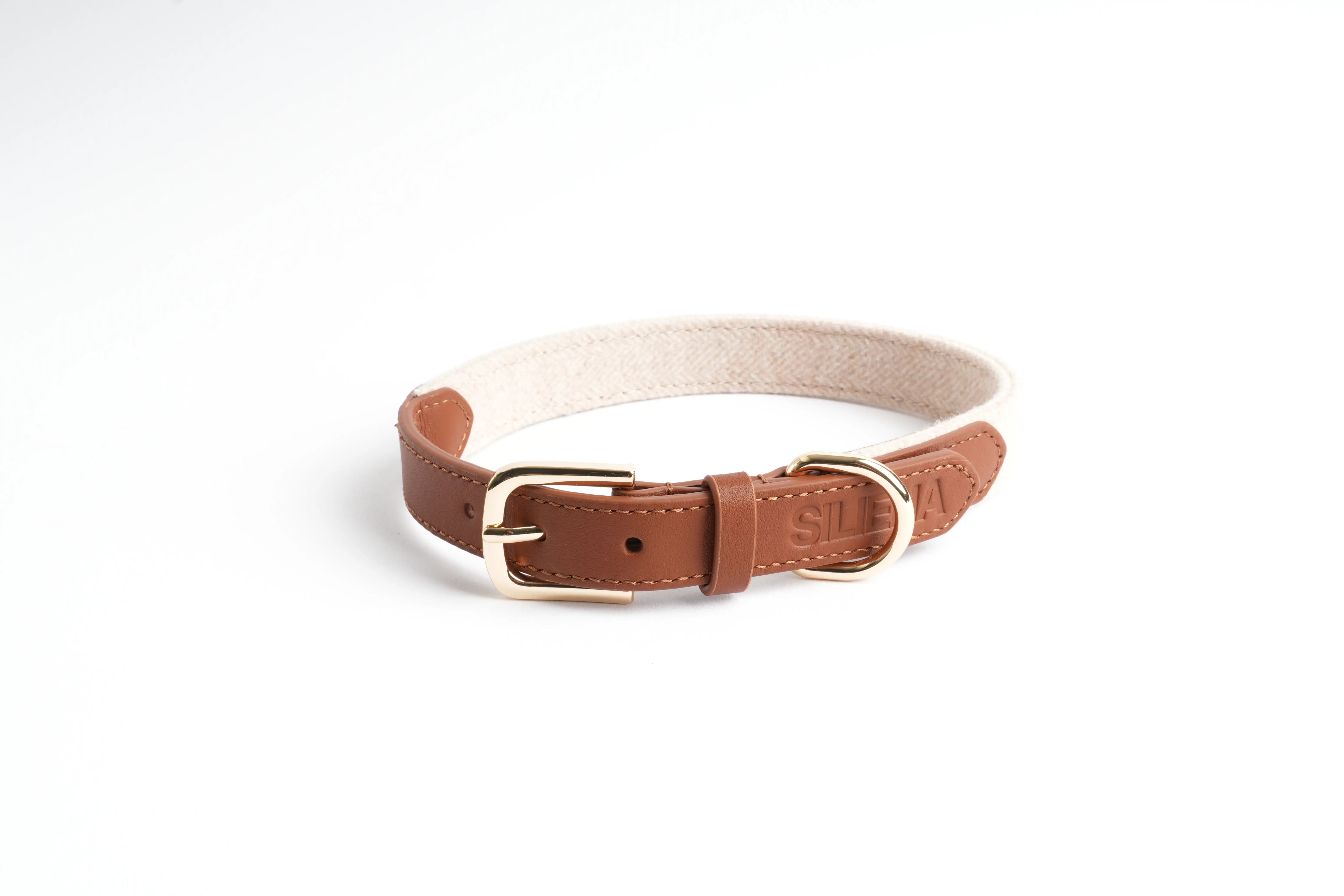 Hundehalsband aus braunem Leder und hellem Textil von Siliena mit goldener Schnalle auf weißem Hintergrund.