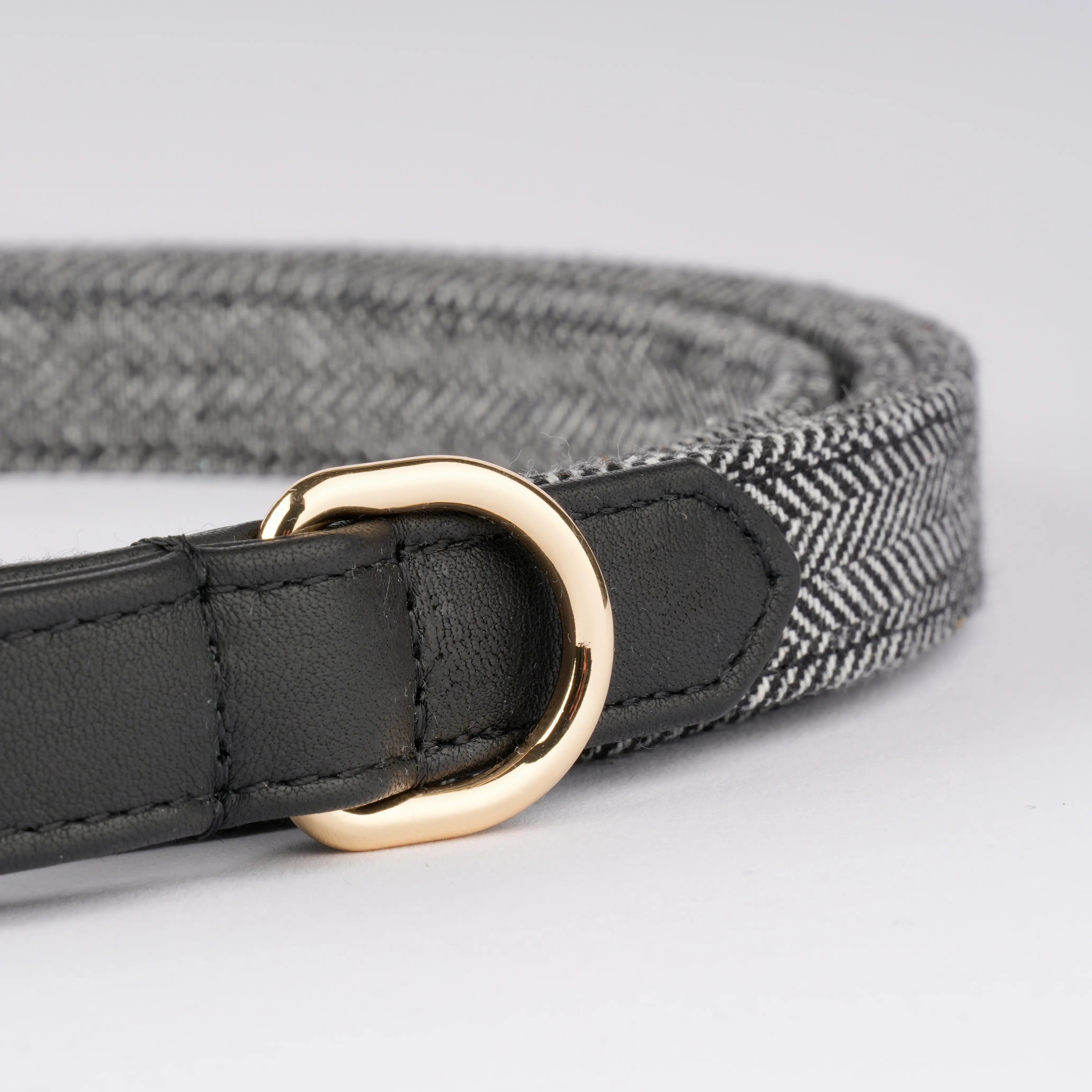 D-Ring-Detailaufnahme der Hundeleine mit Fischgrätmuster und schwarzem Leder