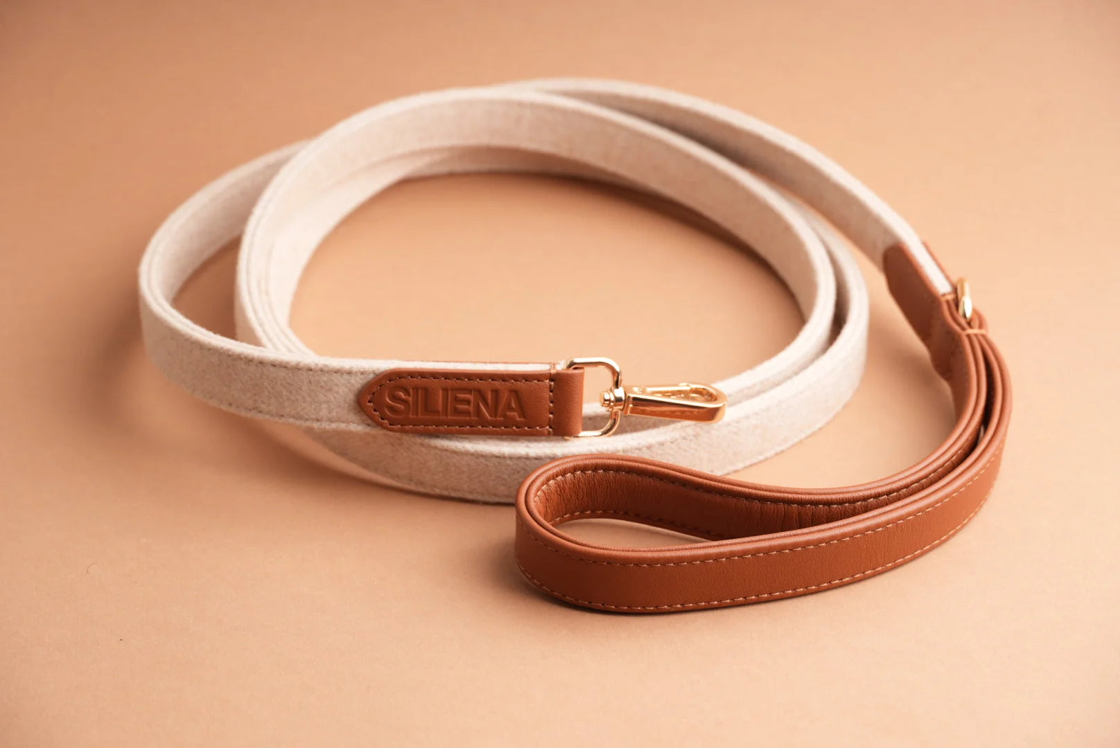 Hundeleine aus beigem Textil mit braunen Lederdetails von Siliena auf hellem Hintergrund.